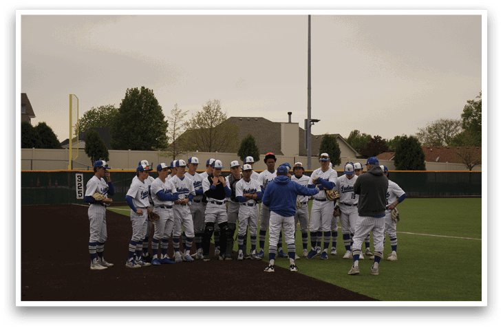 A group of baseball players wearing blue and white uniforms. Description generated by AI