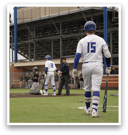 A baseball player holding a bat. Description generated by AI