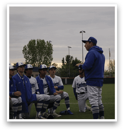 A group of baseball players sitting on the grass. Description generated by AI