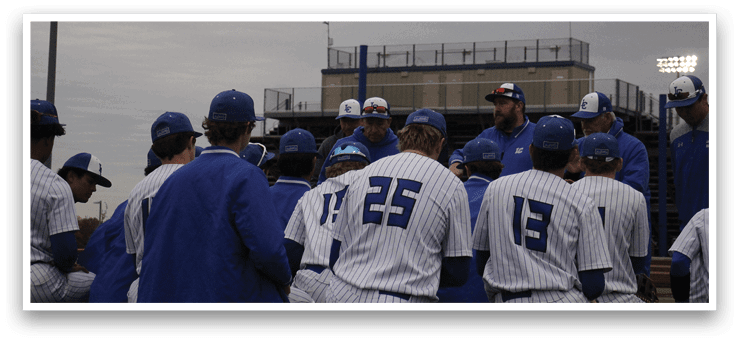 A group of baseball players wearing blue and white uniforms. Description generated by AI