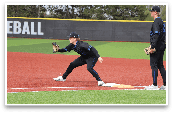 A baseball player wearing a blue shirt and black pants is running towards a base. Description generated by AI