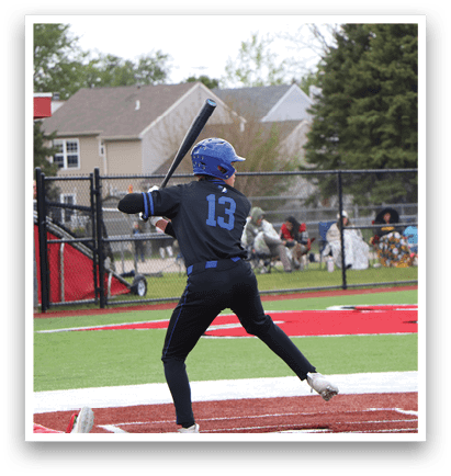 A baseball player is swinging a bat on a field. Description generated by AI