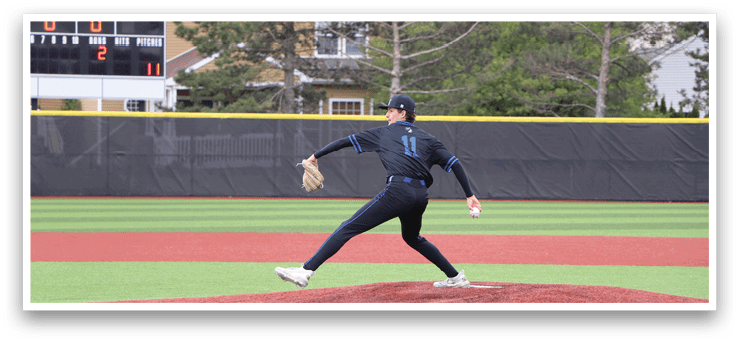 A baseball pitcher in a black and blue uniform is throwing a pitch. Description generated by AI