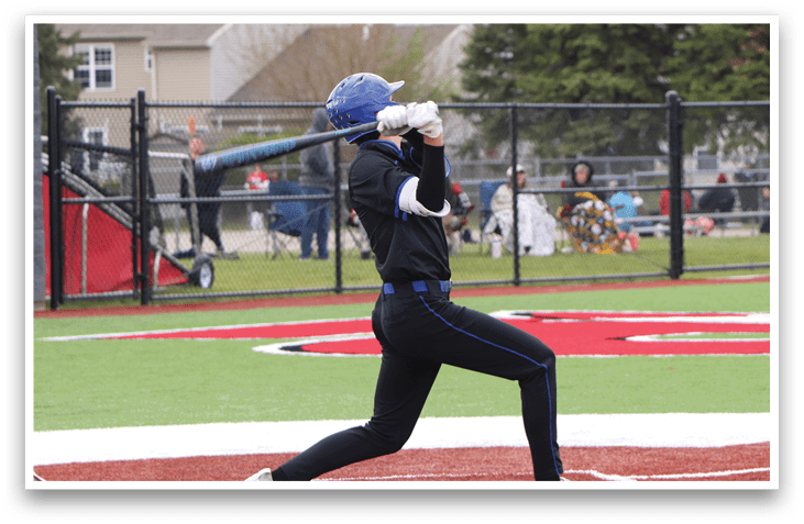 A baseball player in a black shirt and blue pants is swinging a bat. Description generated by AI