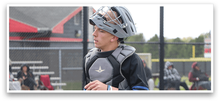 A baseball player wearing a helmet and chest protector. Description generated by AI