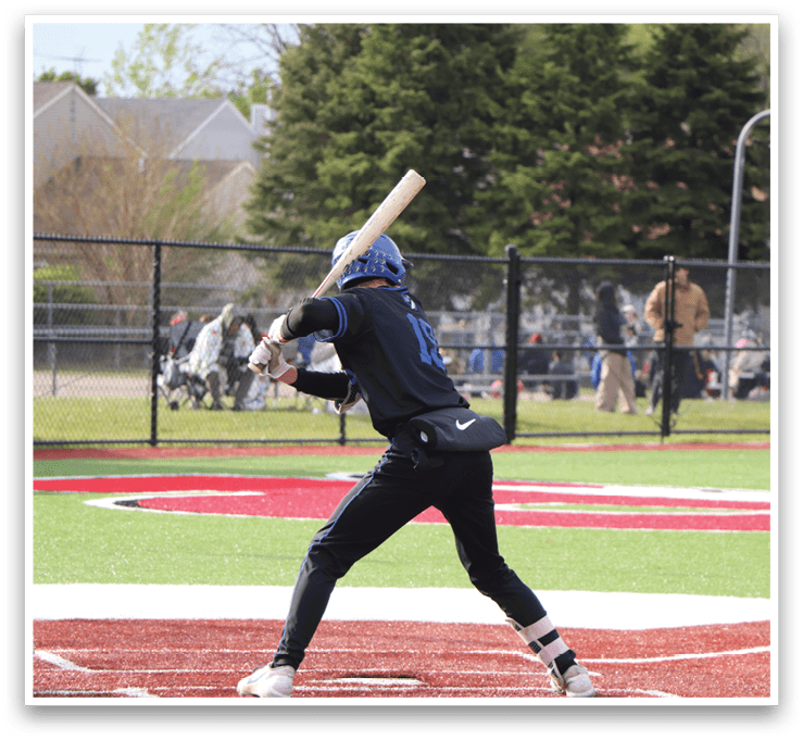 A baseball player in a blue shirt and black pants is swinging a bat. Description generated by AI