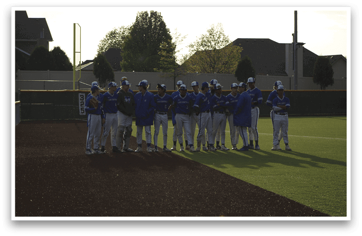 A group of baseball players wearing blue and white uniforms. Description generated by AI