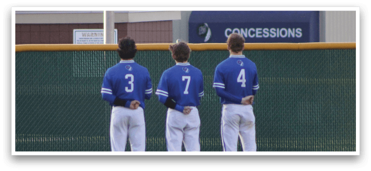 Three baseball players standing on a field. Description generated by AI