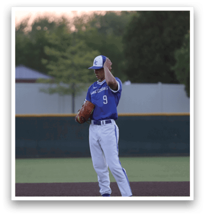 A baseball player in a blue and white uniform is standing on the pitcher's mound. Description generated by AI