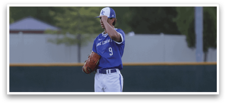 A baseball player in a blue and white uniform is standing on a pitcher's mound. Description generated by AI