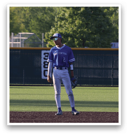 A baseball player in a blue and white uniform is standing on a field. Description generated by AI