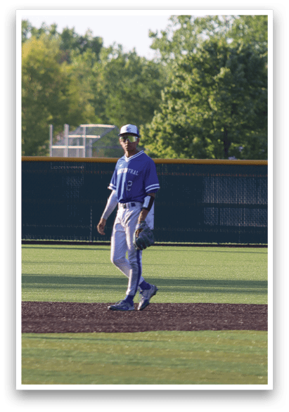 A man wearing a blue shirt and blue hat is walking on a baseball field. Description generated by AI