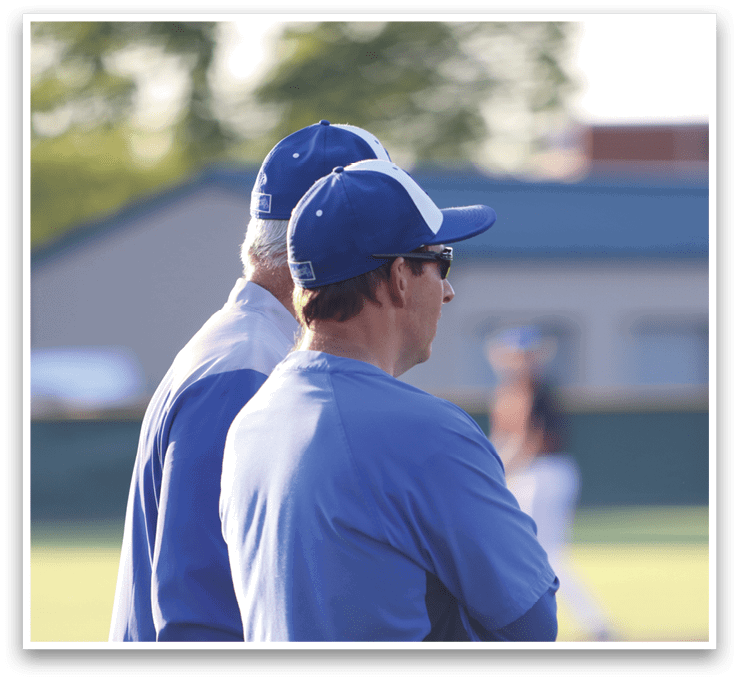 Two men wearing blue shirts and white hats. Description generated by AI