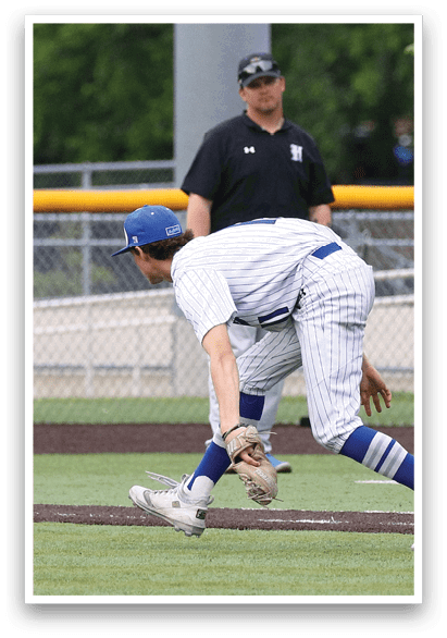A baseball player in a blue hat and white uniform is catching a ball. Description generated by AI