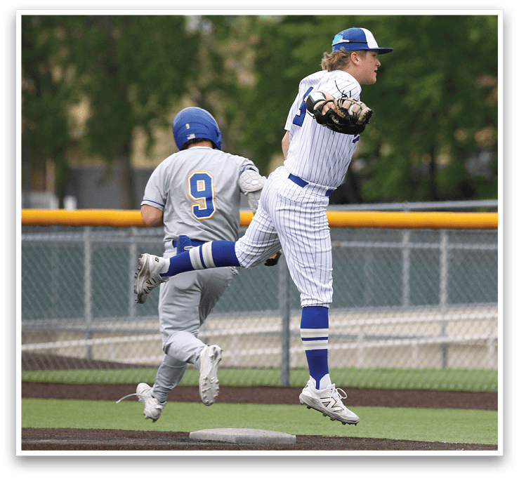 A baseball player in a blue helmet and white uniform is running towards a base. Description generated by AI