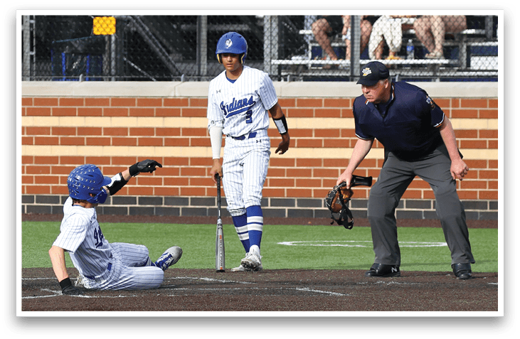 A baseball player slides into home plate. Description generated by AI
