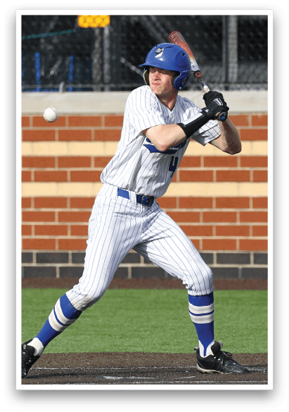 A baseball player in a white and blue uniform is swinging a bat. Description generated by AI