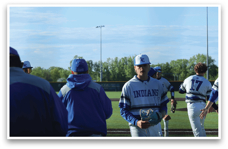 A group of baseball players standing on a field. Description generated by AI