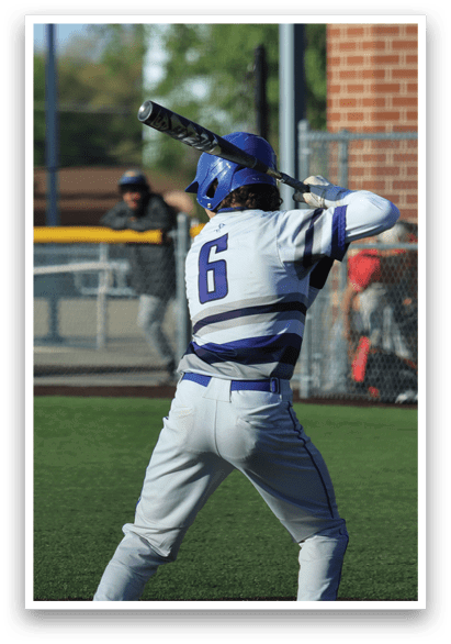 A baseball player in a white and blue uniform is holding a bat and getting ready to hit a ball. Description generated by AI