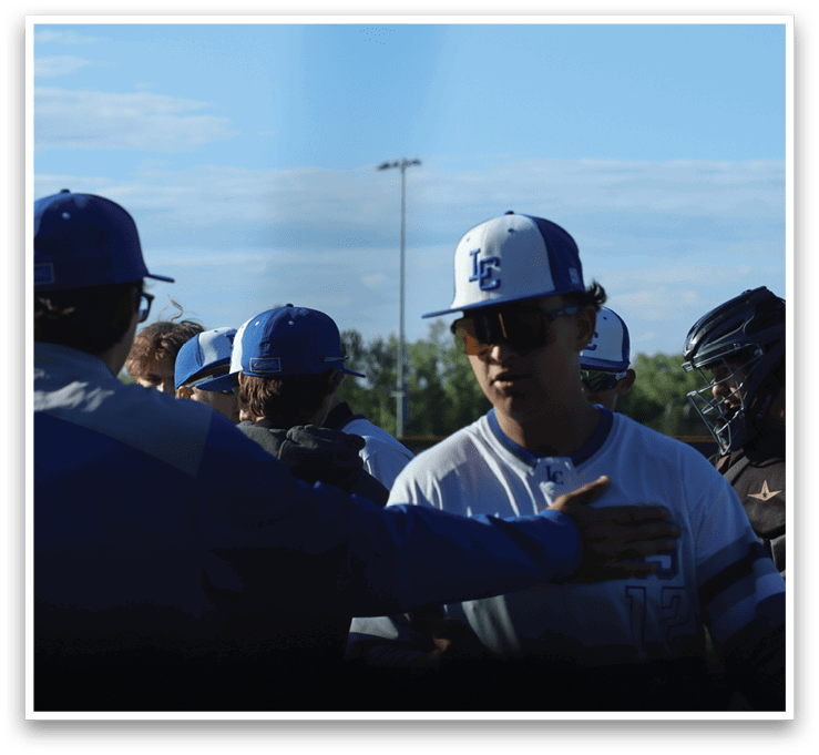 A group of baseball players wearing blue and white uniforms. Description generated by AI
