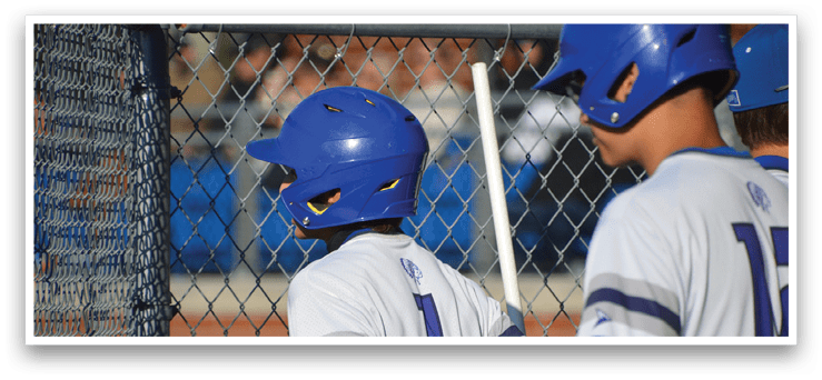 A boy wearing a blue helmet and a white jersey with the number 14 on it. Description generated by AI