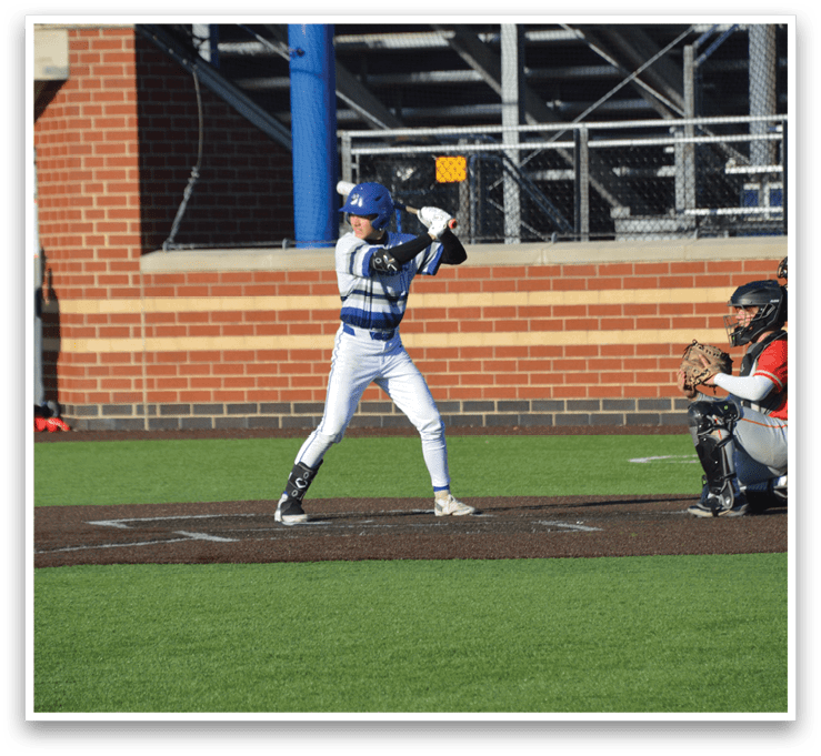 A baseball player in a blue and white uniform is swinging a bat. Description generated by AI