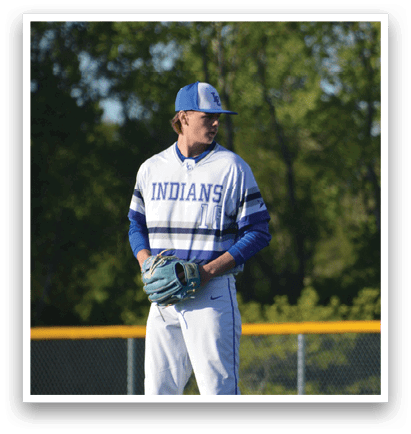 A baseball player wearing a blue and white uniform stands on a field. Description generated by AI