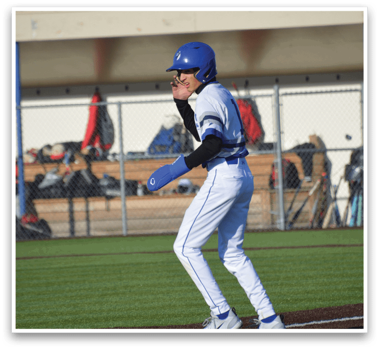 A baseball player wearing a blue helmet and white uniform. Description generated by AI