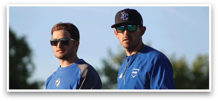 Two men wearing sunglasses and blue shirts. Description generated by AI