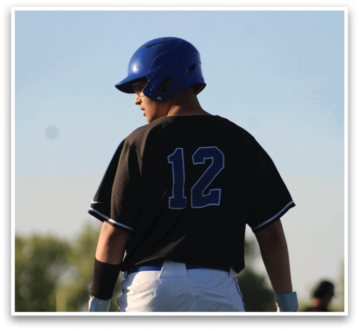 A baseball player wearing a black and blue shirt and a blue helmet. Description generated by AI