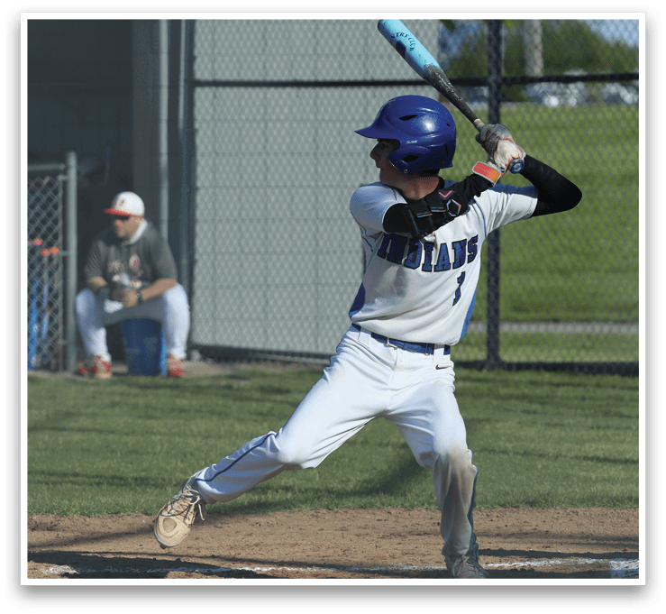 A baseball player in a white and blue uniform is swinging a bat. Description generated by AI