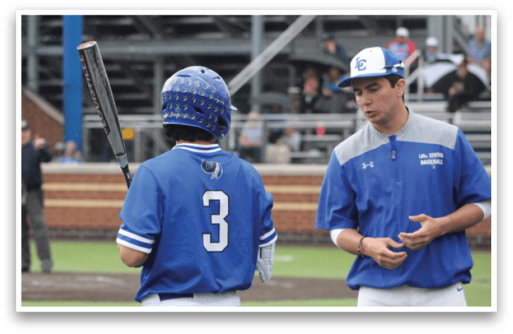A baseball player holding a bat. Description generated by AI