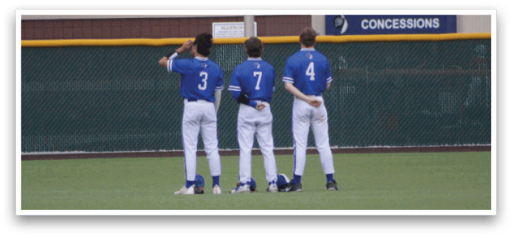 Three baseball players standing on a field. Description generated by AI
