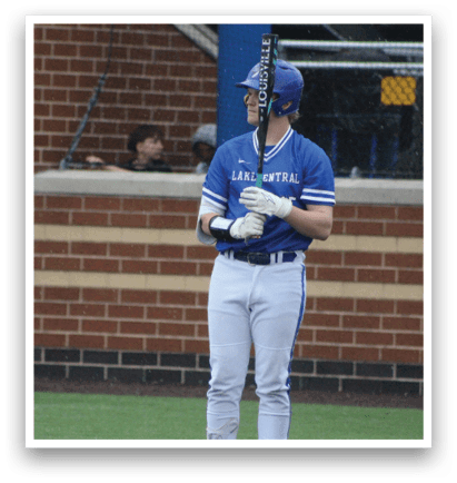 A baseball player in a blue and white uniform holding a bat. Description generated by AI