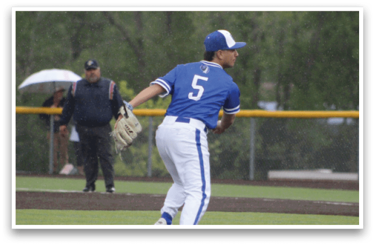 A baseball player wearing a blue shirt and white pants is throwing a ball. Description generated by AI