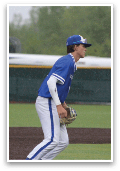 A baseball player in a blue and white uniform with a white glove. Description generated by AI