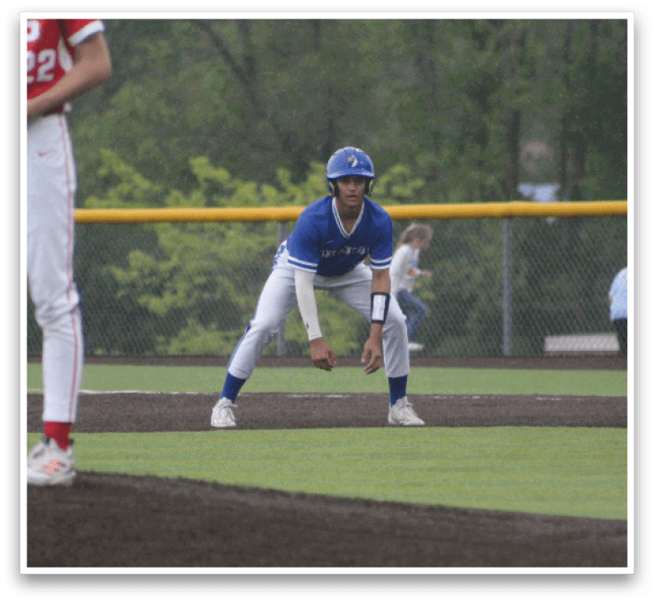 A baseball player in a blue and white uniform is crouching on the field. Description generated by AI