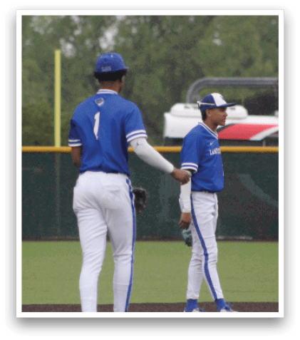 Two baseball players standing on a field. Description generated by AI