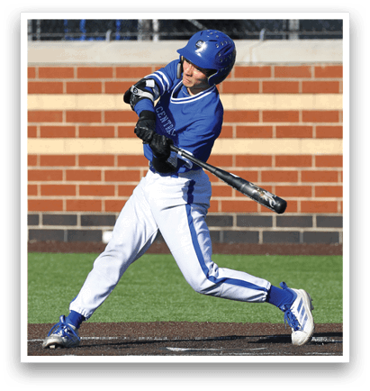 A baseball player in a blue and white uniform is swinging a bat at a ball. Description generated by AI