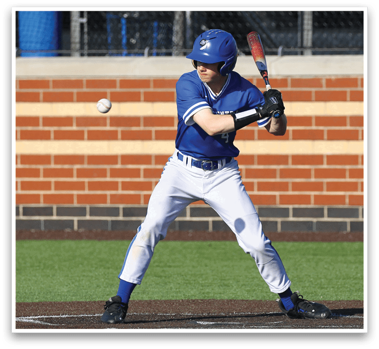 A baseball player in a blue and white uniform is swinging a bat at a ball. Description generated by AI