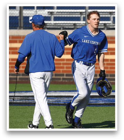 Two men wearing blue shirts and white pants. Description generated by AI