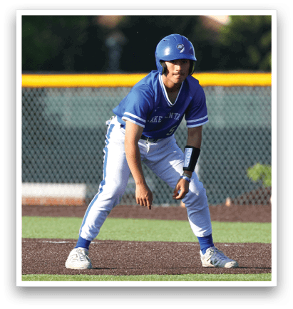 A baseball player in a blue and white uniform is crouched down on the field. Description generated by AI