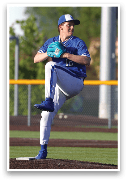 A baseball player in a blue and white uniform is pitching a ball. Description generated by AI