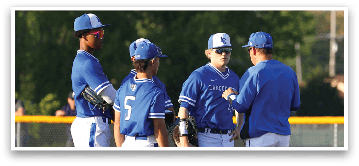 A group of baseball players wearing blue and white uniforms. Description generated by AI
