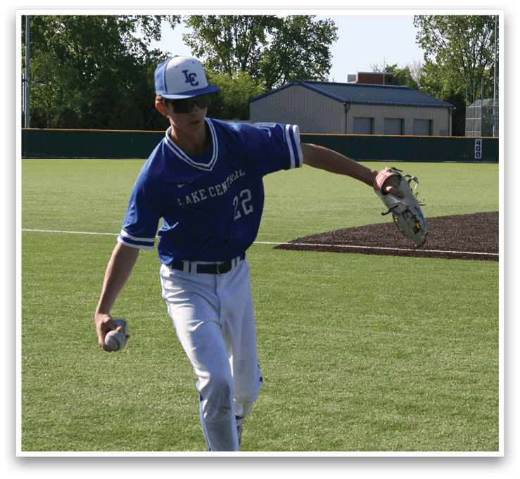 A baseball player in a blue shirt and white pants is throwing a ball. Description generated by AI