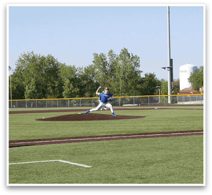 A baseball player in a blue shirt and white pants is throwing a ball. Description generated by AI