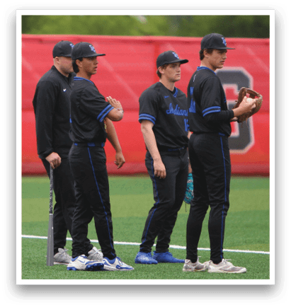 Three baseball players wearing black uniforms and blue shoes. Description generated by AI