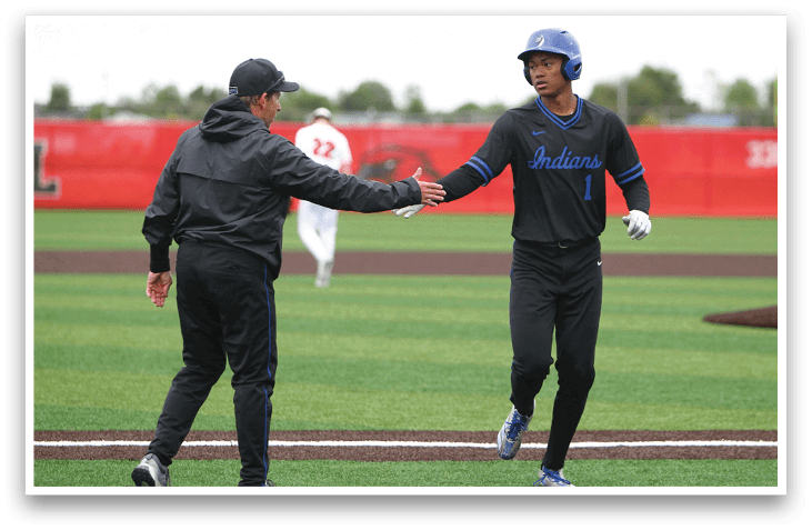 Two men shaking hands on a baseball field. Description generated by AI