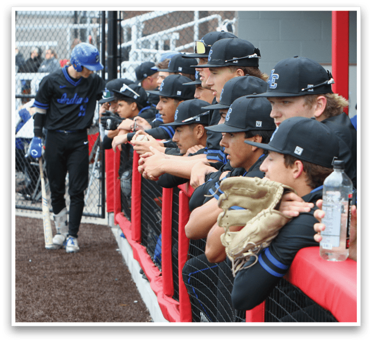 A group of baseball players wearing black shirts and blue caps. Description generated by AI