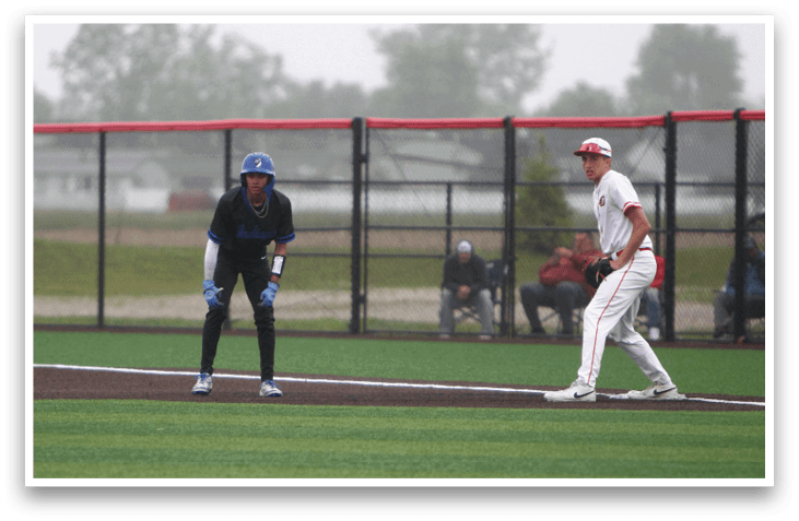 A baseball player wearing a blue helmet and black uniform is ready to catch a ball. Description generated by AI